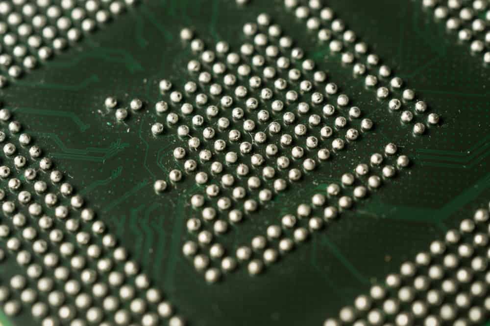 A high-resolution macro photograph of a Ball Grid Array (BGA) on a green printed circuit board, serving as a featured image for a case study on SolVision AI soldering inspection.