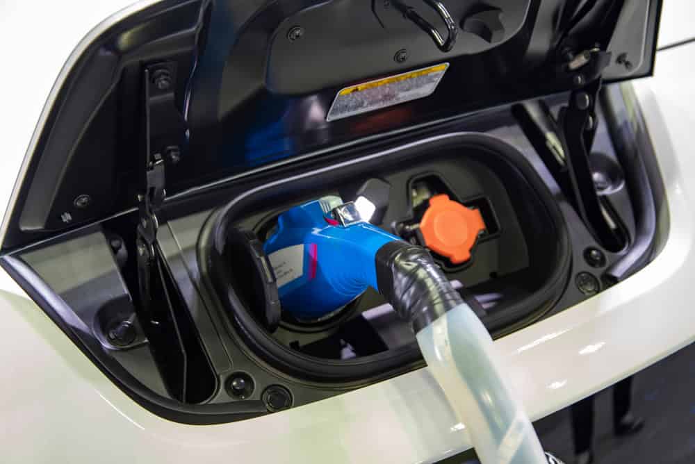 Electric car at charging station with the power cable supply plugged