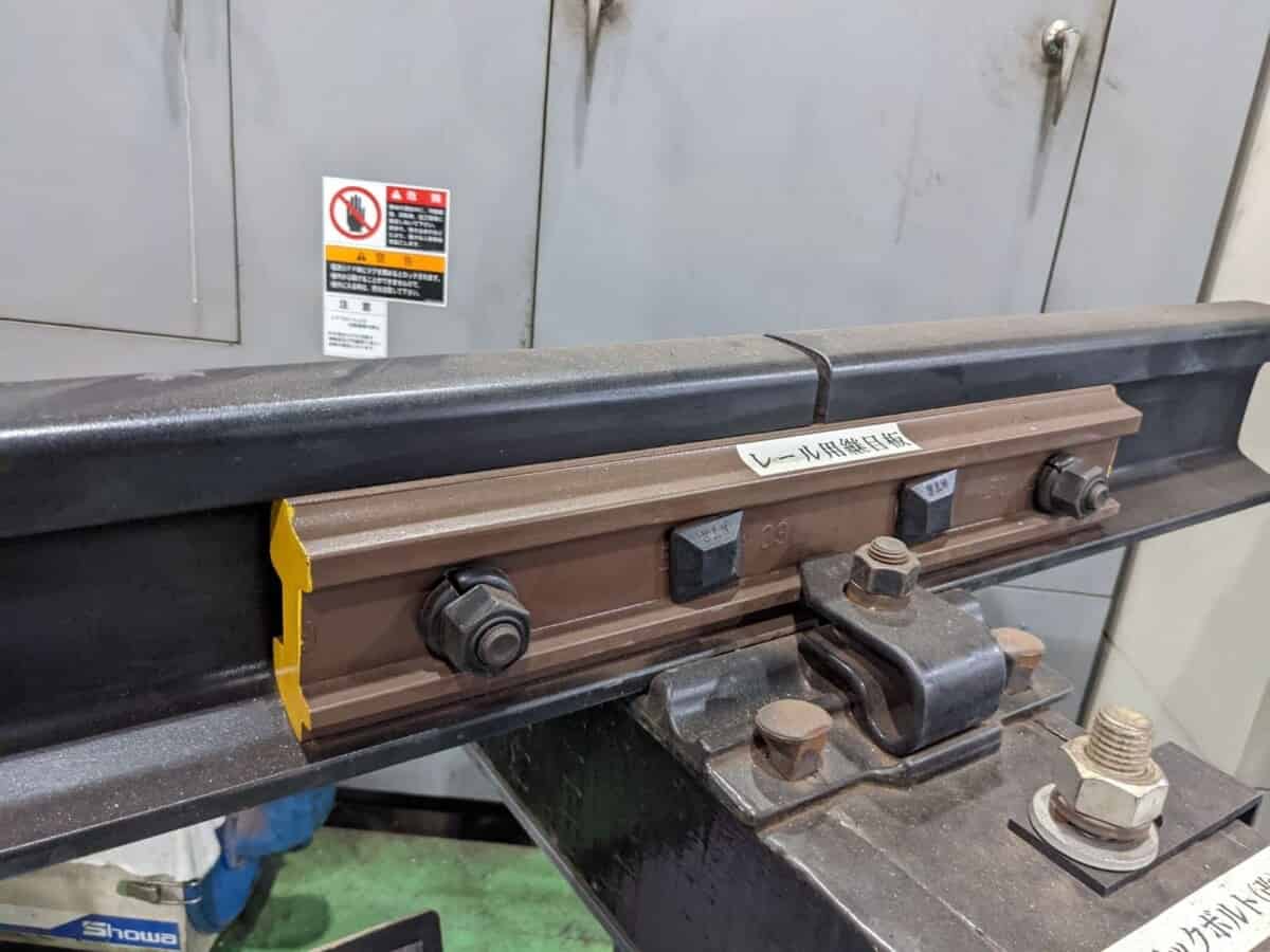 close up of a rail point plate undergoing edge trimming