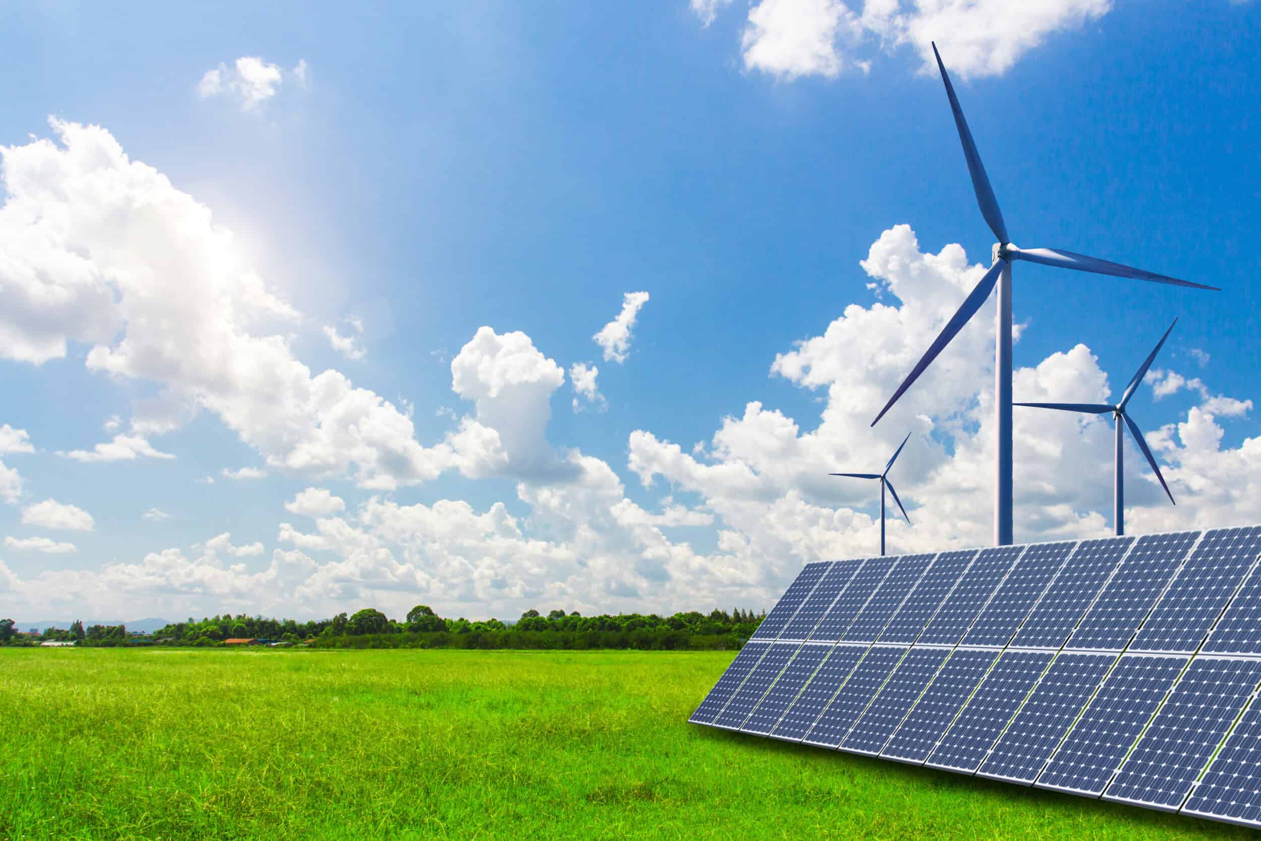Image of a wind turbine and solar panel in a field with green grass and a blue sky