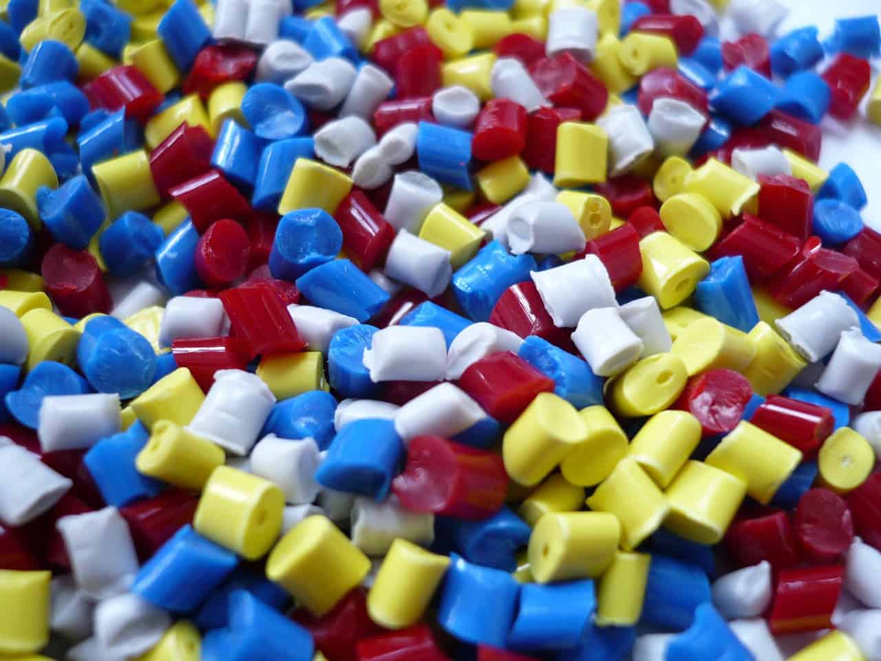 blue, red, white, and yellow colored plastic polymer granules