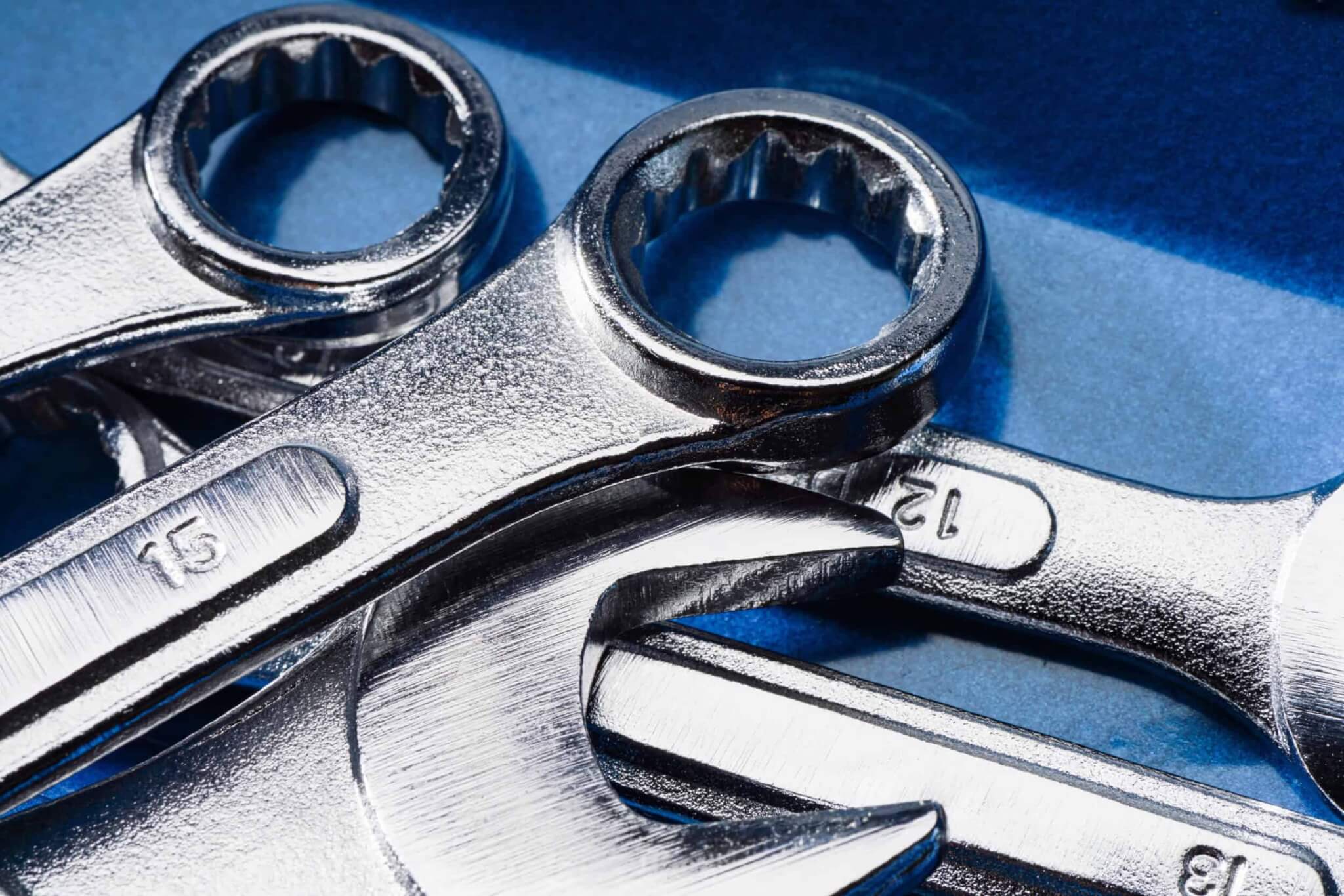 set of steel wrenches and spanners on a blue background