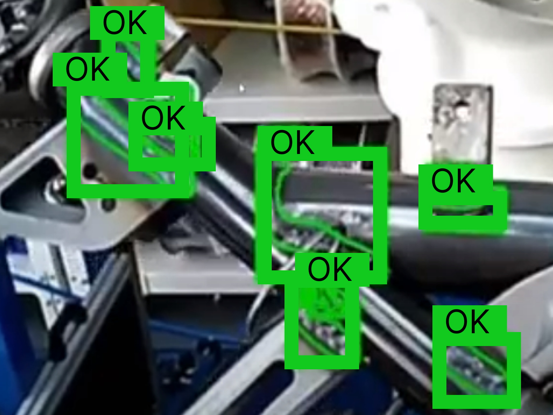A close-up view of an industrial component undergoing AI quality inspection, with green bounding boxes and "OK" labels clearly indicating successful identification of compliant parts in a manufacturing process.